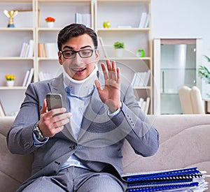 Man in neck brace cervical collar working from home teleworking