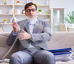 Man in neck brace cervical collar working from home teleworking