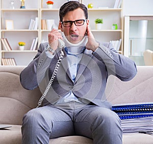 Man in neck brace cervical collar working from home teleworking