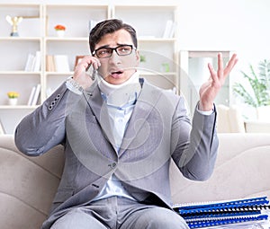 Man in neck brace cervical collar working from home teleworking