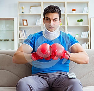 Man with neck injury watching boxing at home