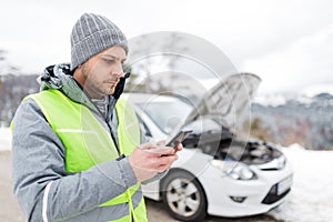 Man next to breakdown car calling for help by using his mobile phone