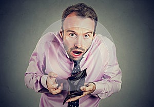 Man with no money. Businessman holding showing empty wallet photo