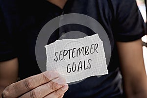 Man with a note with the text september goals