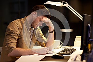 Man with notepad working late at night office