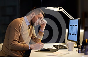 Man with notepad working at night office