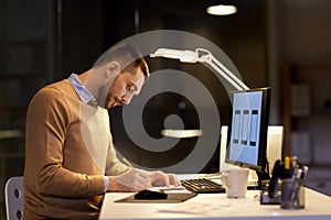 Man with notepad working at night office