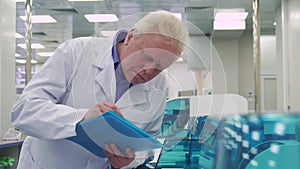 Man notes report about laboratory machine work