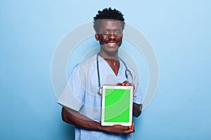 Man nurse showing vertical green screen on tablet
