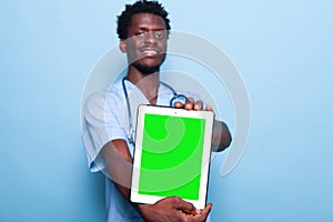 Man nurse showing vertical green screen on tablet