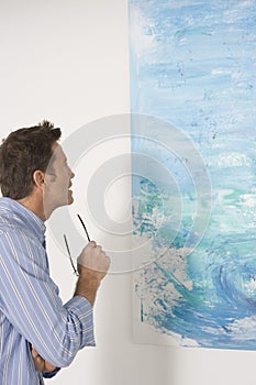 Man Observing Painting In Art Gallery