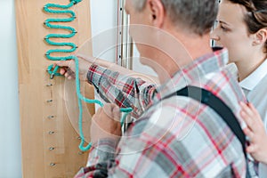 Man in occupational therapy with therapist training his dexterity