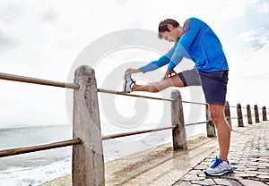 Man, ocean and stretching for fitness with exercise to jog, health and fresh with wellness and body care. Male person