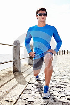 Man, ocean and stretching for fitness with workout to jog, health and wellness with body care in Chicago. Male person