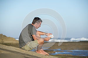 Man by Oceand reading and listenting to music photo