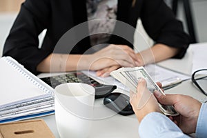 Man offering batch of hundred dollar bills