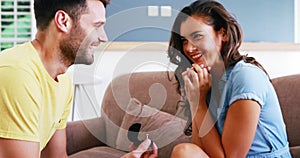 Man offering a engagement ring to woman in the living room