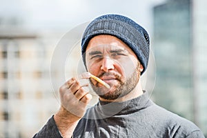 Man offering a french frie close up view - urban background