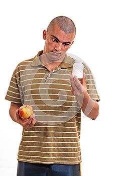 Man offering pill in one hand and apple in another.