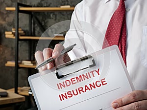 A man offers a indemnity insurance form for a signature.