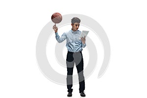 Man in office clothes playing basketball on white background. Unusual look for businessman in motion, action. Sport