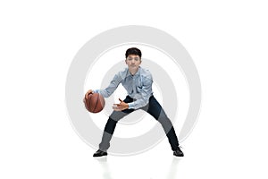 Man in office clothes playing basketball on white background. Unusual look for businessman in motion, action. Sport