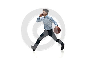 Man in office clothes playing basketball on white background. Unusual look for businessman in motion, action. Sport