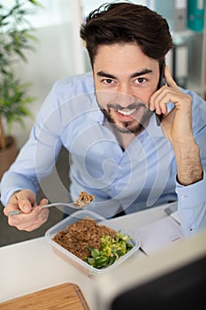 man at office eat green salad healthy food