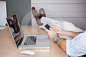 Man in office with feet on desk and laptop