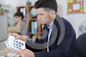 Man in office looking at booklet color samples