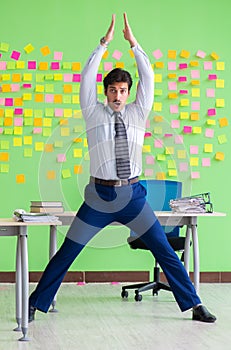 Man in the office with many conflicting priorities doing exercis