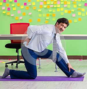 Man in the office with many conflicting priorities doing exercis