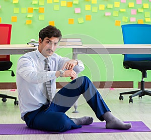 Man in the office with many conflicting priorities doing exercis