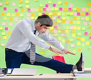 Man in the office with many conflicting priorities doing exercis