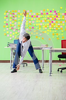 The man in the office with many conflicting priorities doing exercises