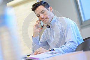 Man in office with mobile phone photo