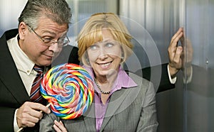 Man in office offers coworker a lollipop