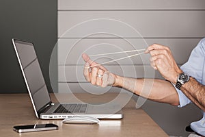 Man in office playing with rubber band