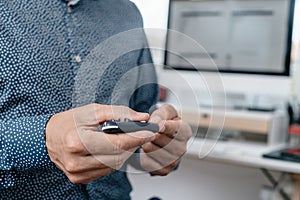 man in the office pricking his finger with a fingerstick