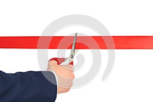 Man in office suit cutting red ribbon isolated on white