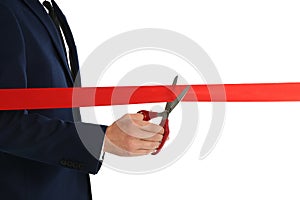 Man in office suit cutting red ribbon  on white
