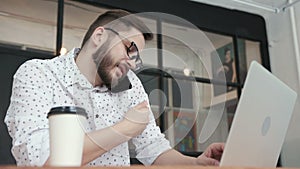 Man in office talking at phone and type at laptop