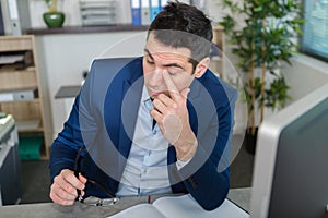 man in office touching eye