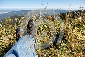 Man in old boots lied on top of the mountain