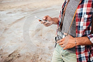 Man with old vintage photo camera using cell phone