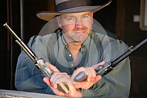 Man in old West clothing wielding two pistols