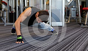 Man one arm push-ups in gym