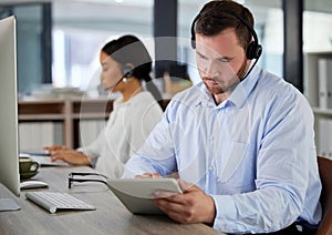 Man, online and tablet in call center office for emails or messages, training apps and crm information. People, agent