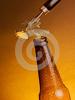 Man open fresh cold beer ale bottles with drops and stopper open with bottle opener