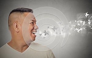 Man with open mouth blowing cold breeze snowflakes flying away